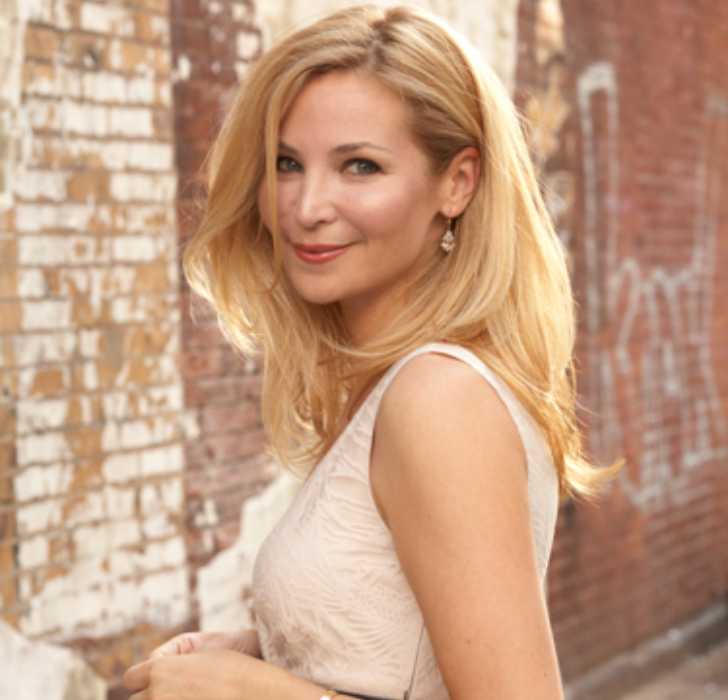 Picture of Jennifer Westfeldt in white dress posing for the photo with smile on her face.